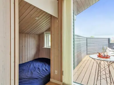 a bed in a sauna on the balcony of a house at Holiday Home Alma - 500m from the sea by Interhome in Løkken