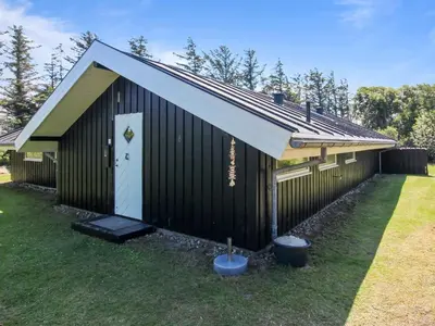 a building with a white door and a roof at Holiday Home Alban - 700m from the sea by Interhome in Løkken