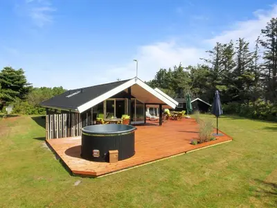 a house with a deck and a hot tub at Holiday Home Alban - 700m from the sea by Interhome in Løkken