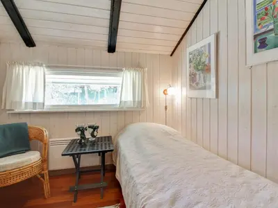 a bedroom with a bed and a table and a chair at Holiday Home Alban - 700m from the sea by Interhome in Løkken