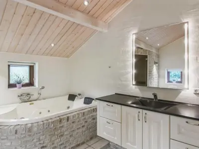 a bathroom with a tub and a sink and a bath tub at Holiday Home Ran - 1-5km from the sea by Interhome in Saltum