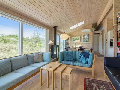 a living room with a couch and a table at Holiday Home Sampo - 400m from the sea by Interhome in Løkken