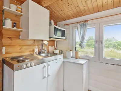 a kitchen with a sink and a microwave at Holiday Home Sampo - 400m from the sea by Interhome in Løkken