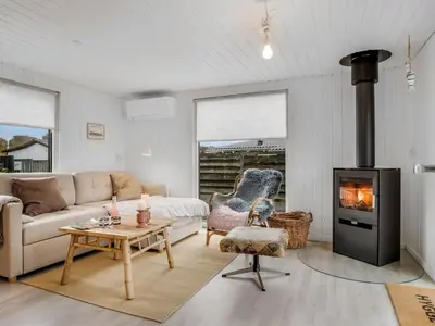 a living room with a couch and a fireplace at Holiday Home Kielo - 200m to the fjord by Interhome in Løgstør