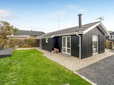 a black house with a lawn in front of it at Holiday Home Kielo - 200m to the fjord by Interhome in Løgstør