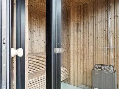 a room with wooden walls and a glass door at Holiday Home Bena - 800m from the sea by Interhome in Blokhus