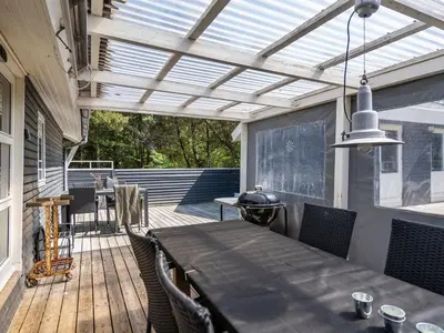 a patio with a table and chairs on a deck at Holiday Home Aneline - 700m from the sea by Interhome in Saltum