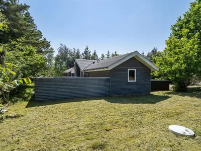a small house in a yard with a frisbee at Holiday Home Aneline - 700m from the sea by Interhome in Saltum