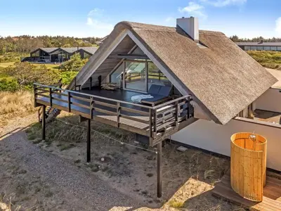 a small house with a thatched roof on top of it at Holiday Home Mumme - 700m from the sea by Interhome in Blokhus
