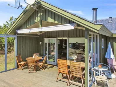 a patio with a table and chairs on a deck at Holiday Home Gerasim - 1km from the sea by Interhome in Saltum