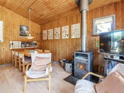 a living room with a wood stove and a table at Holiday Home Gerasim - 1km from the sea by Interhome in Saltum