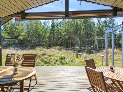 a patio with a table and chairs on a deck at Holiday Home Gerasim - 1km from the sea by Interhome in Saltum