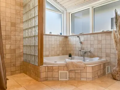 a bathroom with a tub and a window at Holiday Home Sazdo - 1-1km from the sea by Interhome in Saltum