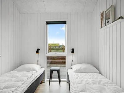 two beds in a room with a window at Holiday Home Egil - 1-5km from the sea by Interhome in Saltum