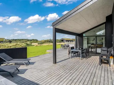a wooden deck with a table and chairs at Holiday Home Egil - 1-5km from the sea by Interhome in Saltum