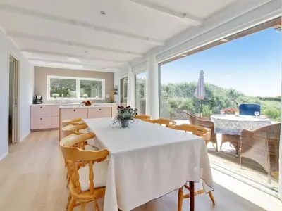 a kitchen and dining room with a white table and chairs at Holiday Home Hoat - 300m from the sea by Interhome in Saltum