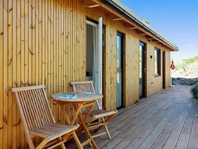 a patio with two chairs and a table on a deck at Holiday Home Hoat - 300m from the sea by Interhome in Saltum
