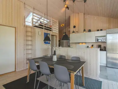 a kitchen with a table and chairs in a room at Holiday Home Ascan - 600m from the sea by Interhome in Løkken