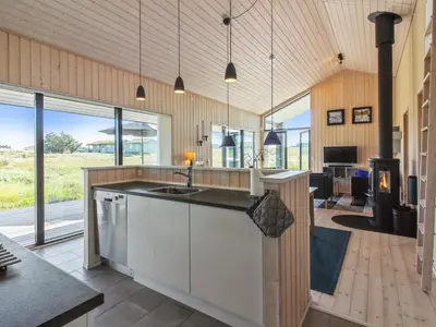 an open kitchen with a sink and a living room at Holiday Home Ascan - 600m from the sea by Interhome in Løkken