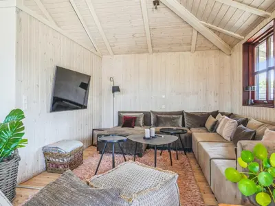 a living room with a couch and tables at Holiday Home Fridgerd - 250m from the sea by Interhome in Blokhus