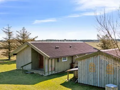 a house with a roof on a grass field at Holiday Home Tianna - 500m from the sea by Interhome in Pandrup