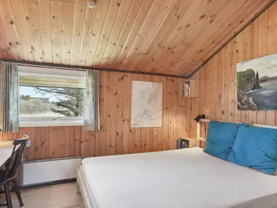 a bedroom with a bed in a wooden room at Holiday Home Tianna - 500m from the sea by Interhome in Pandrup