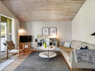 a living room with a couch and a table at Holiday Home Apsolon - 600m from the sea by Interhome in Løkken