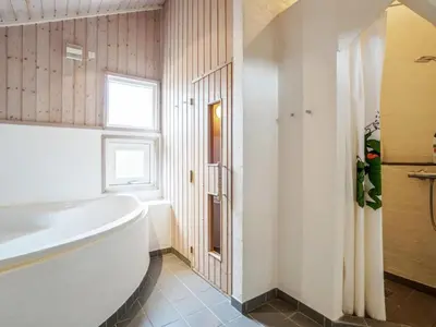 a white bathroom with a tub and a window at Holiday Home Franzisca - 700m from the sea by Interhome in Saltum