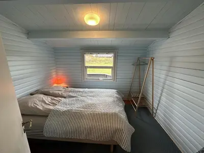 a bedroom with a bed in a room with a window at Holiday Home Freding - 450m from the sea by Interhome in Løkken