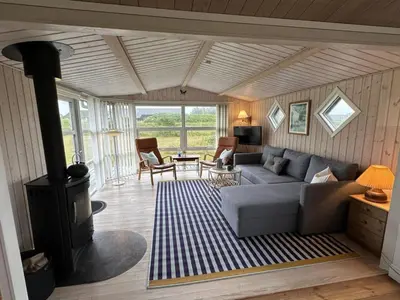 a living room with a couch and a wood stove at Holiday Home Freding - 450m from the sea by Interhome in Løkken
