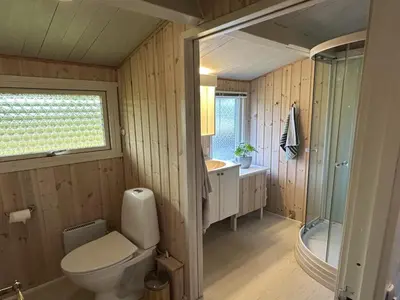 a bathroom with a toilet and a sink and a shower at Holiday Home Freding - 450m from the sea by Interhome in Løkken