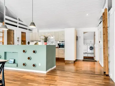 a kitchen with white cabinets and a blue wall at Holiday Home Valda - 1-5km from the sea by Interhome in Saltum