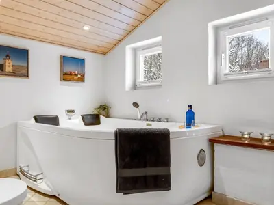 a bathroom with a bath tub and a sink at Holiday Home Valda - 1-5km from the sea by Interhome in Saltum
