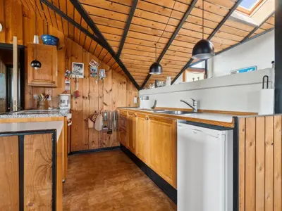 a kitchen with wooden cabinets and a sink at Holiday Home Henri - 500m from the sea by Interhome in Fjerritslev