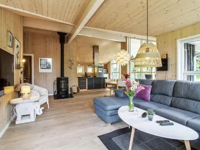 a living room with a blue couch and a table at Holiday Home Arlett - 950m from the sea by Interhome in Fjerritslev