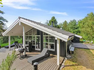 a house with a wooden deck with a roof at Holiday Home Arlett - 950m from the sea by Interhome in Fjerritslev