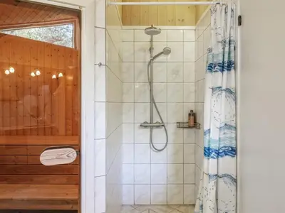 a shower with a shower curtain in a bathroom at Holiday Home Arlett - 950m from the sea by Interhome in Fjerritslev