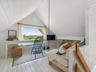 a bedroom with a bed and a chair and a window at Holiday Home Nadia - 300m to the fjord by Interhome in Fur