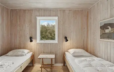 two beds in a room with a window at Awesome Home In Løkken in Løkken