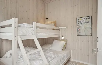 a room with two bunk beds in it at Awesome Home In Løkken in Løkken