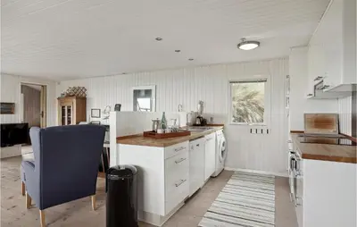 a kitchen with a white refrigerator and a sink at Awesome Home In Løkken in Løkken