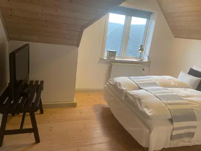a bedroom with a bed and a television in it at Thyholm B&B in Thyholm