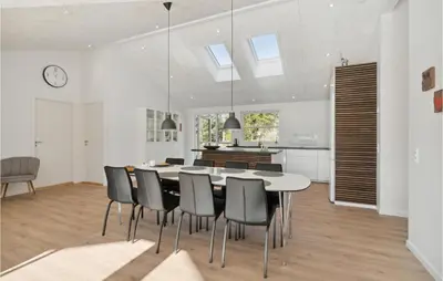 a kitchen and dining room with a table and chairs at 4 Bedroom Awesome Home In Blokhus in Blokhus