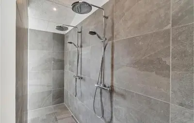 a shower with a glass door in a bathroom at 4 Bedroom Awesome Home In Blokhus in Blokhus