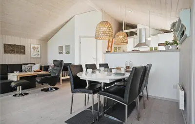 a dining room with a white table and black chairs at Amazing Home In Vestervig With Kitchen in Vestervig