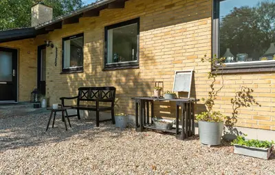 a chair and a table next to a building at Awesome Home In Nykøbing M in Hesselbjerg