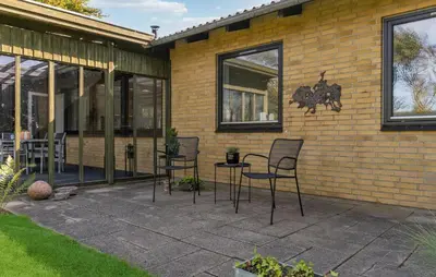 a patio with chairs and a table in front of a building at Awesome Home In Nykøbing M in Hesselbjerg