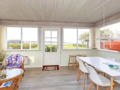 a living room with a table and chairs and windows at 6 person holiday home in Skals-By Traum in Skals