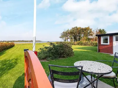 a patio with a table and chairs and a windmill at 6 person holiday home in Skals-By Traum in Skals