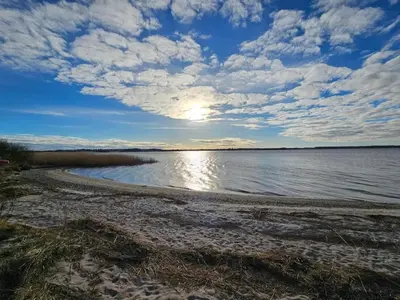 a beach with the sun reflecting on the water at 4 star holiday home in Skals-By Traum in Skals